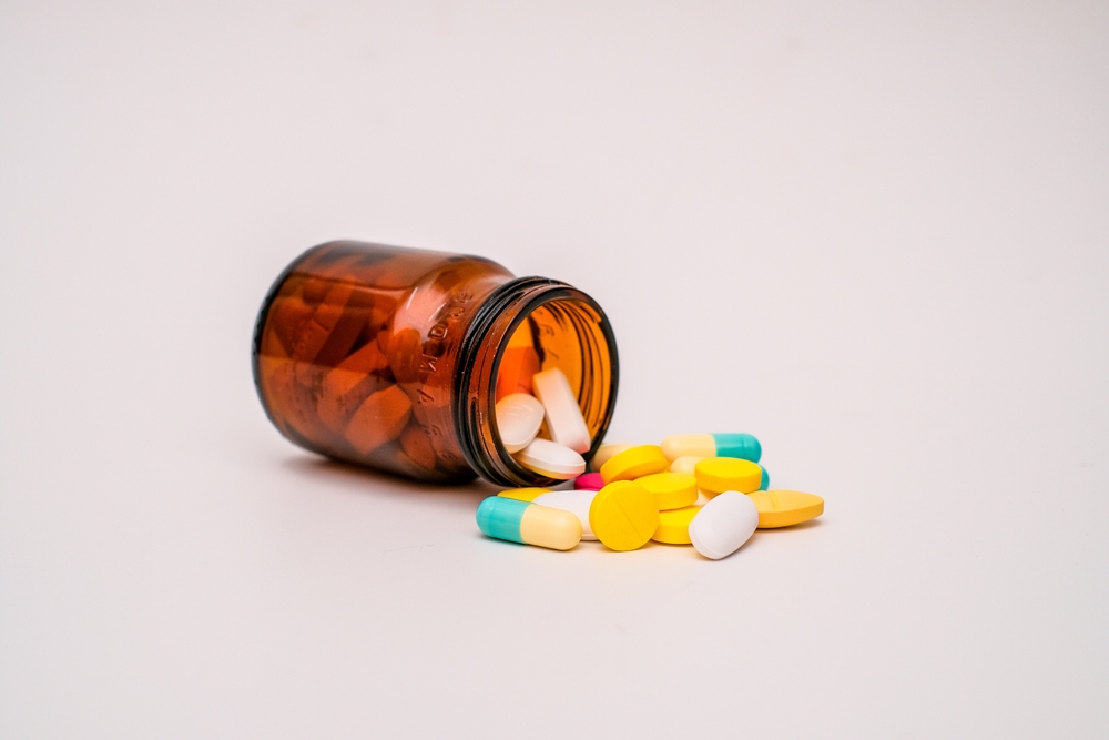 A,bottle,of,pills,spilling,out,on,white,surface