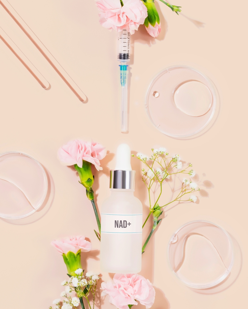 Nad,skincare,bottle,with,syringe,,lab,tools,,and,delicate,flowers