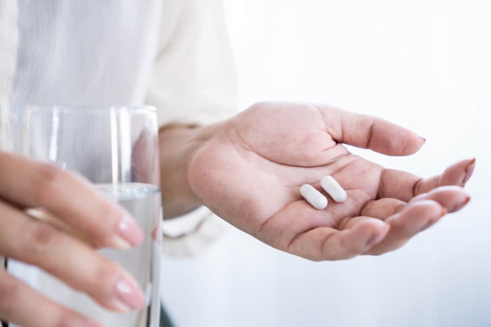 Closeup,woman,hand,taking,probiotics,,prebiotics,to,fight,an,infection,