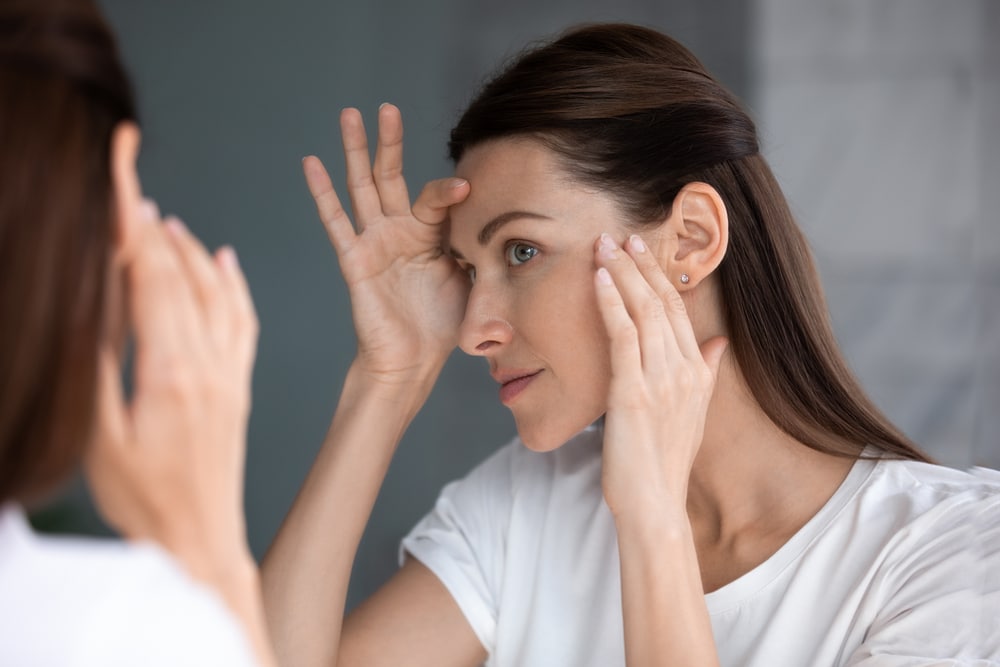Close,Up,Of,Woman,Looking,In,Mirror,Check,Face,After LMNT in Sandy, UT