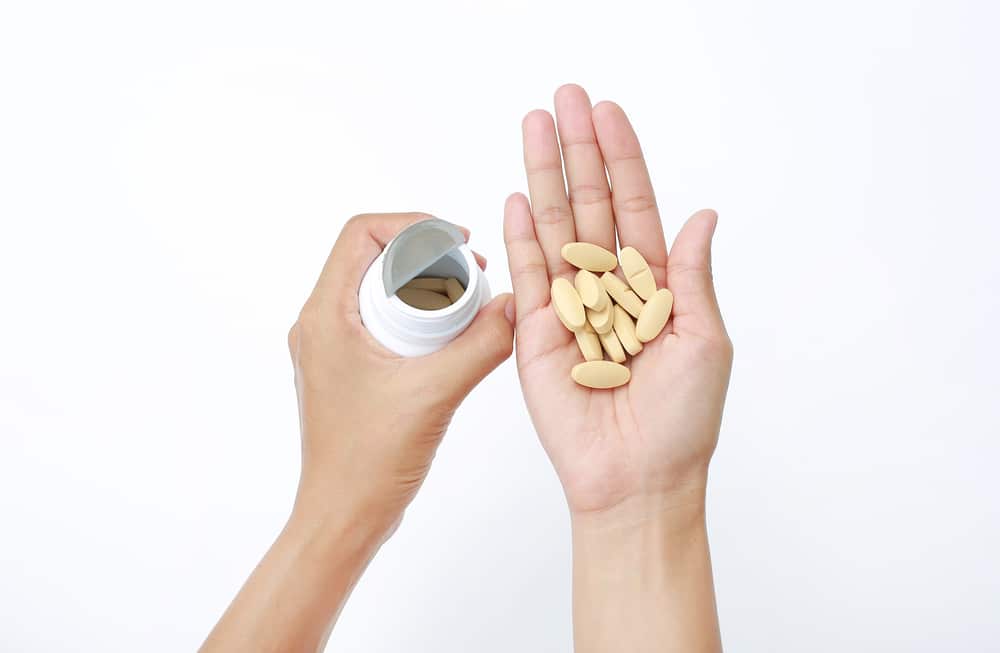 Hand,Holding,Yellow,Pill,Isolated,On,White,Background