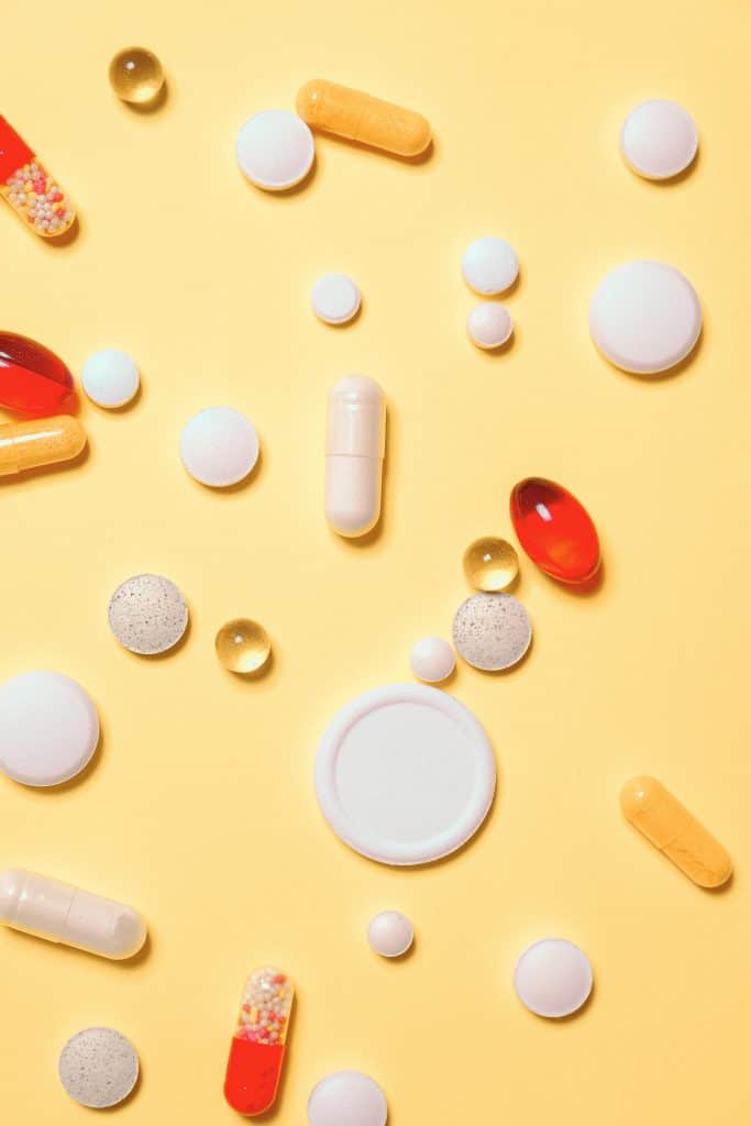 pexels-photo-3683041-3683041 Colorful assortment of pills and capsules on a vibrant yellow background.