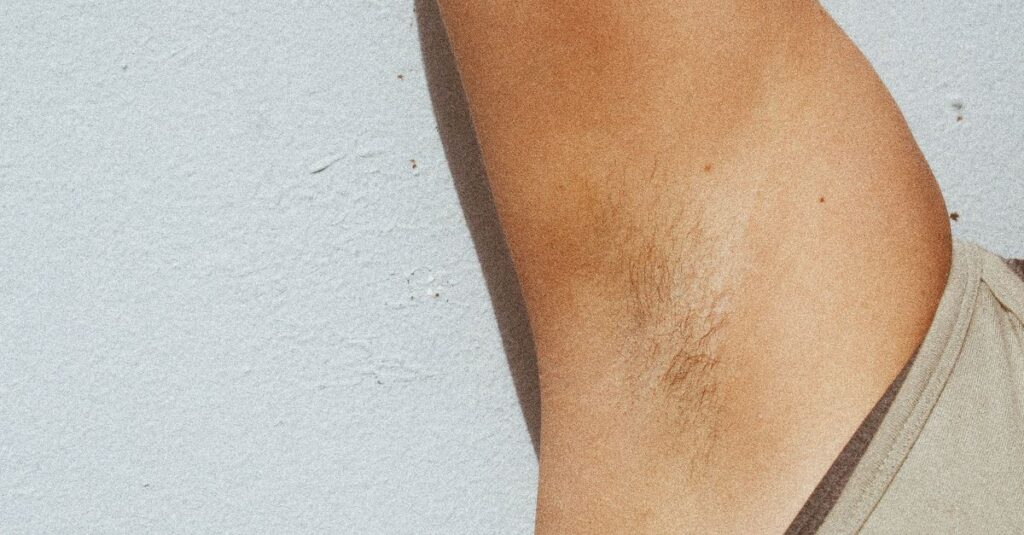 pexels-photo-8517480-8517480 Detailed image of a natural human armpit, depicting body hair and skin tone in sunlight.