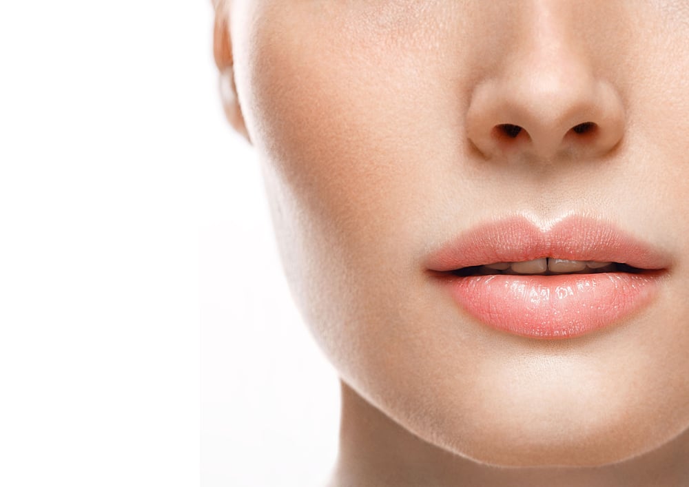 Woman with fuller, symmetrical lips after lip filler treatment.